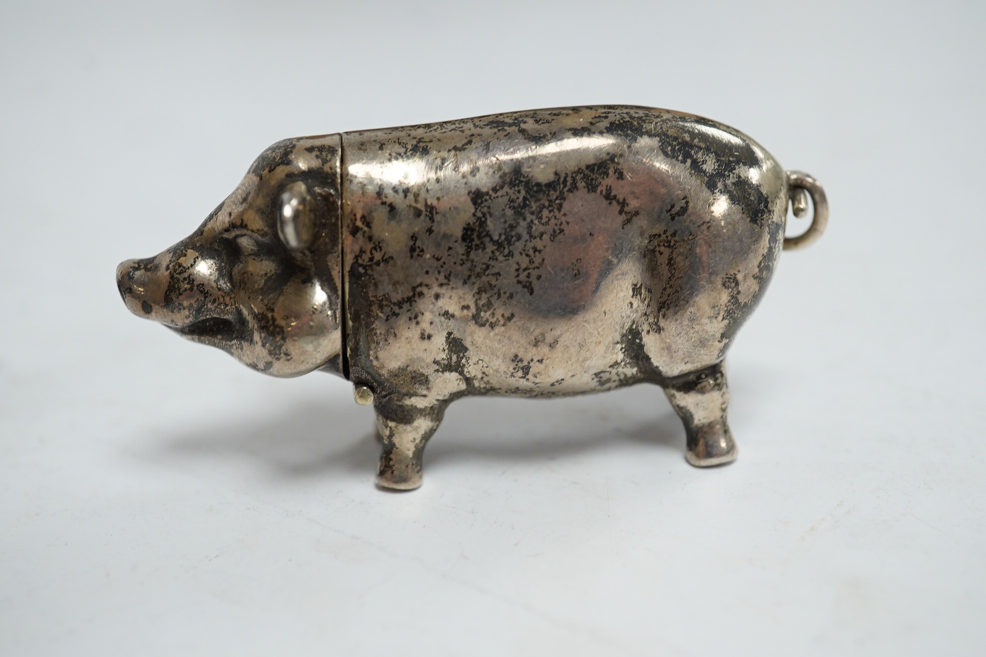 A modern silver novelty vesta case modelled as a pig, by David A. Bowles, London, 1902, 62mm, together with a novelty sterling whistle modelled as a dog's head. Condition - fair to good